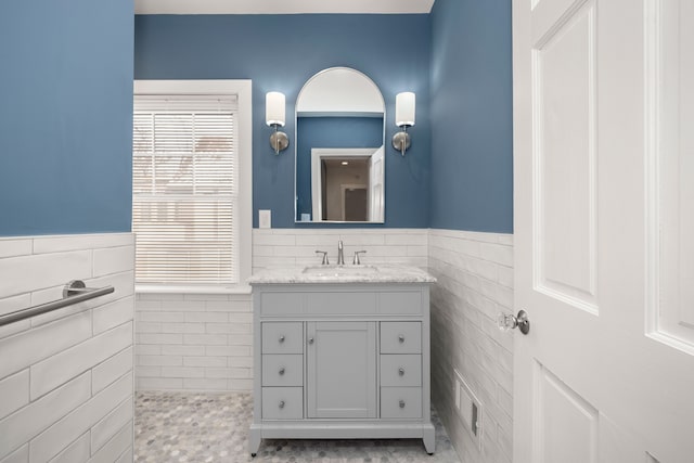 bathroom featuring vanity and tile walls