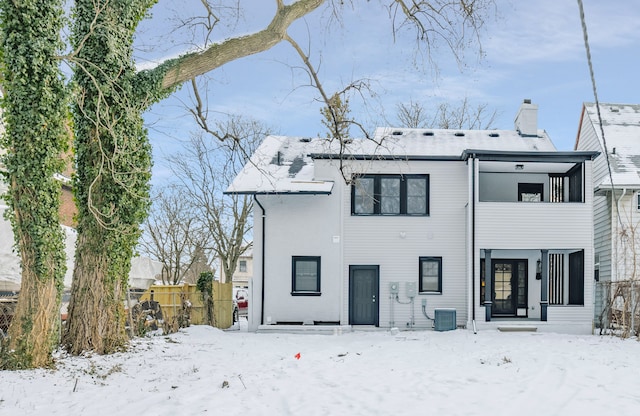 snow covered back of property with central air condition unit