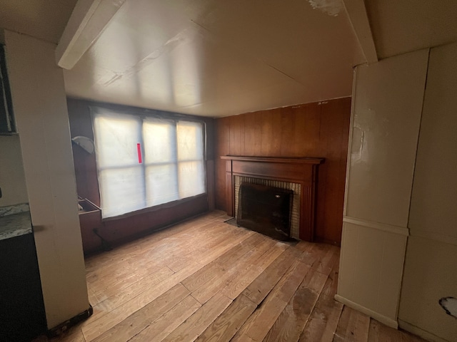 living room with a brick fireplace and light wood-type flooring