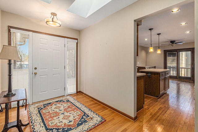 entryway with a skylight, light hardwood / wood-style flooring, and ceiling fan