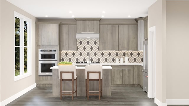 kitchen with decorative backsplash, dark wood-type flooring, stainless steel double oven, and a kitchen bar