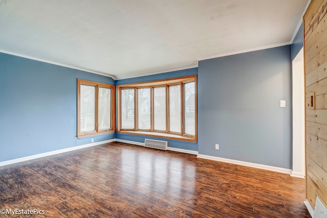 spare room featuring crown molding and dark wood-type flooring