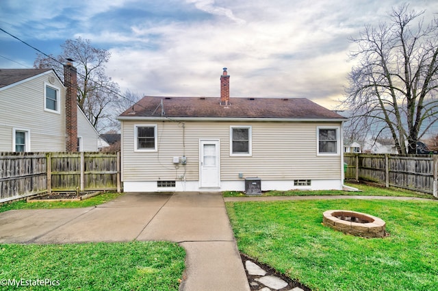 rear view of house featuring a patio area, a fire pit, and a lawn