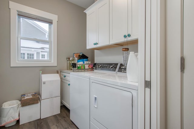 washroom featuring washer and dryer, dark hardwood / wood-style floors, and cabinets