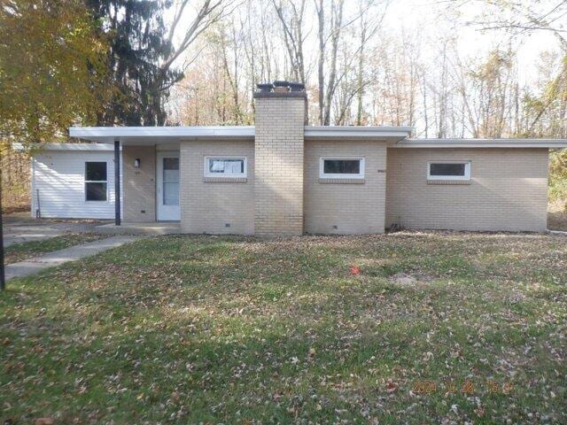 rear view of property featuring a lawn