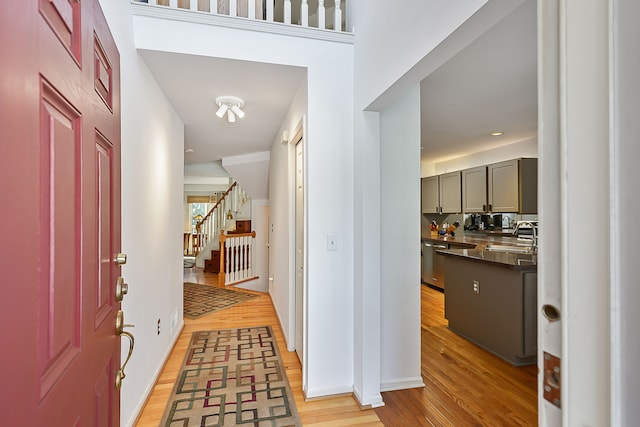 foyer entrance with sink and light hardwood / wood-style flooring