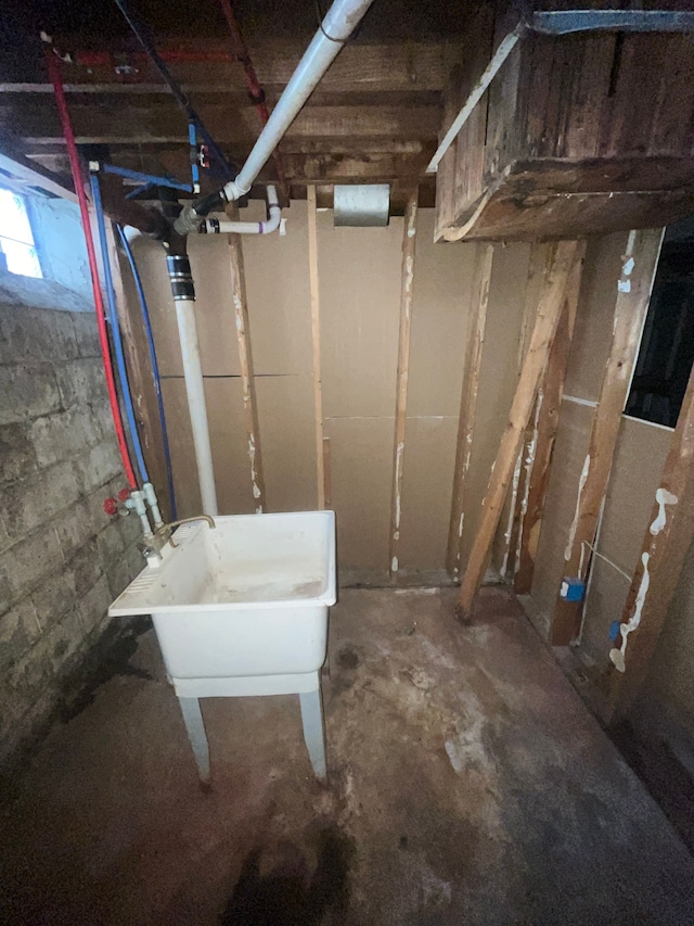 below grade area featuring concrete block wall and a sink