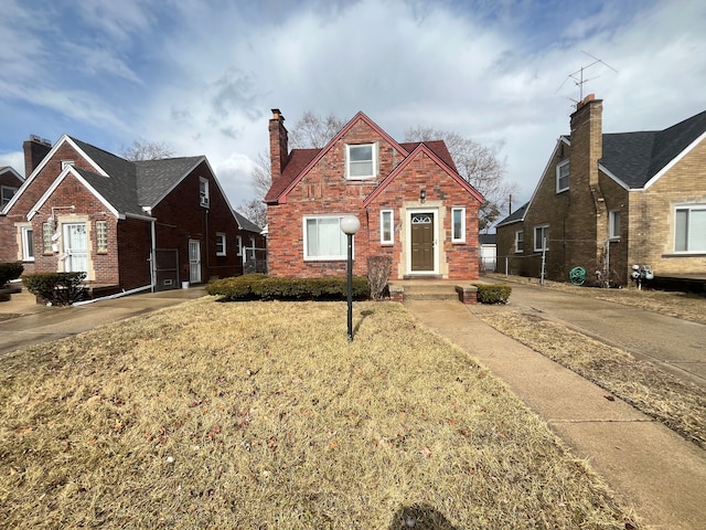 view of front of home featuring a chimney and brick siding