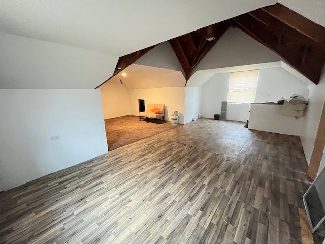 additional living space featuring wood finished floors and vaulted ceiling