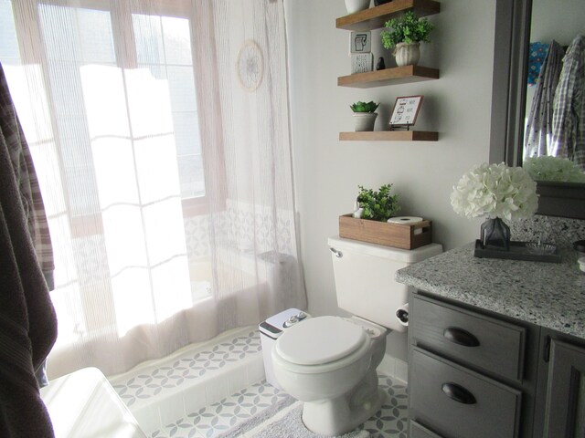 bathroom with tile patterned flooring, vanity, a wealth of natural light, and toilet