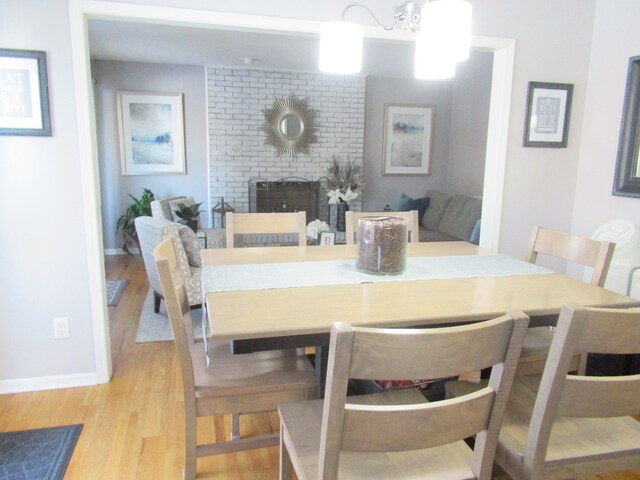 dining area with a fireplace and light hardwood / wood-style flooring