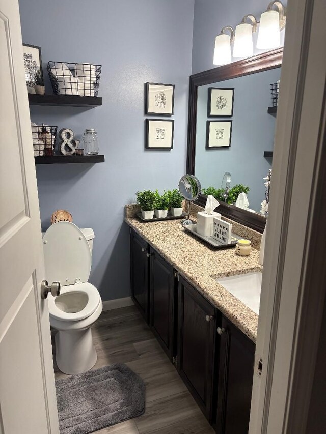 bathroom with vanity, toilet, and hardwood / wood-style floors