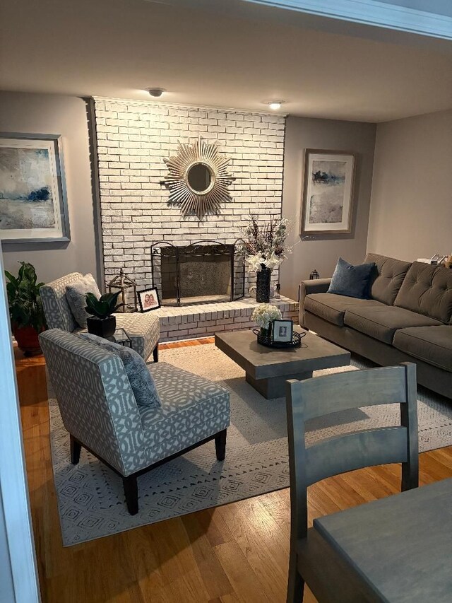 living room featuring hardwood / wood-style flooring and a brick fireplace