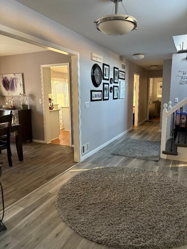 corridor with hardwood / wood-style flooring