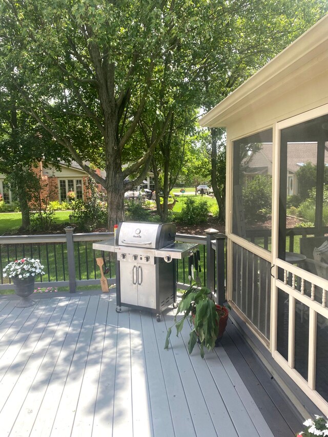 deck with area for grilling and a sunroom