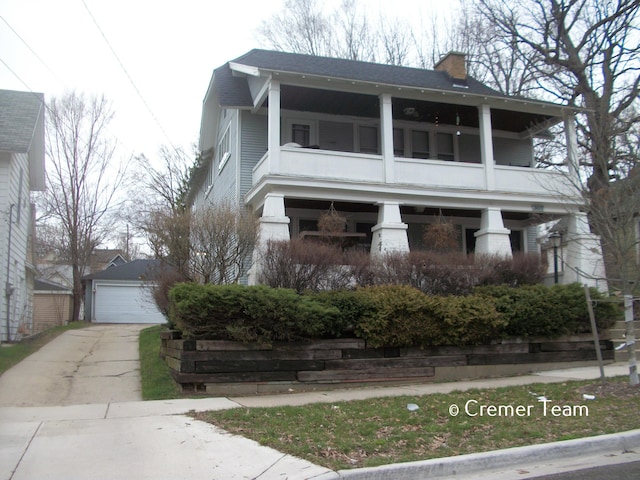 view of front of home with a balcony, a garage, and an outdoor structure