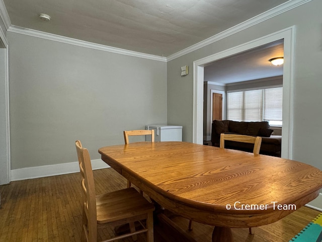 dining space featuring crown molding and dark hardwood / wood-style floors