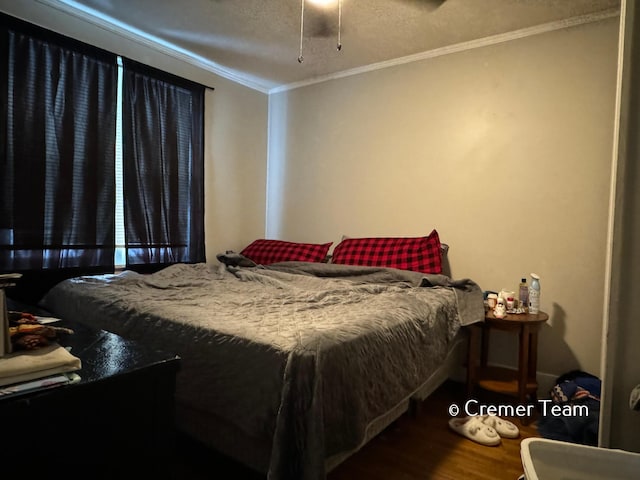 bedroom with hardwood / wood-style floors, crown molding, and a textured ceiling