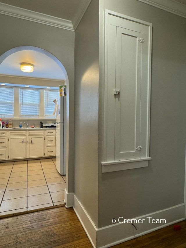 interior space with ornamental molding, sink, and light hardwood / wood-style floors