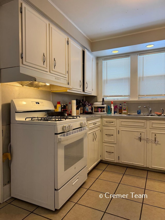 kitchen with white cabinetry, sink, light tile patterned floors, and white range with gas stovetop