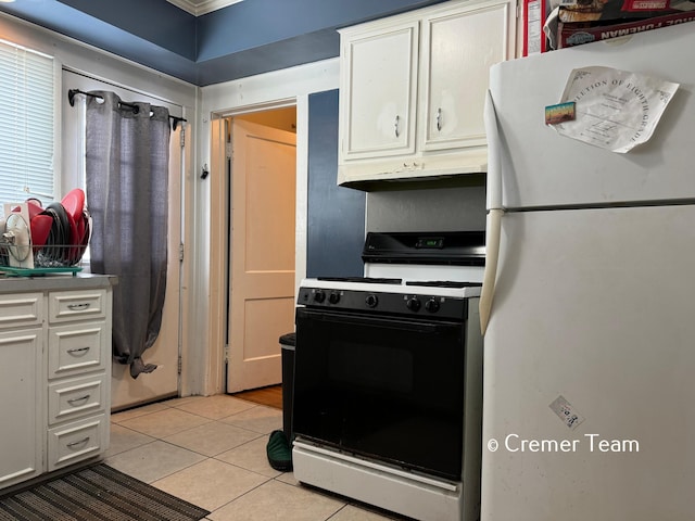 kitchen with light tile patterned floors, white refrigerator, ornamental molding, white cabinets, and gas range