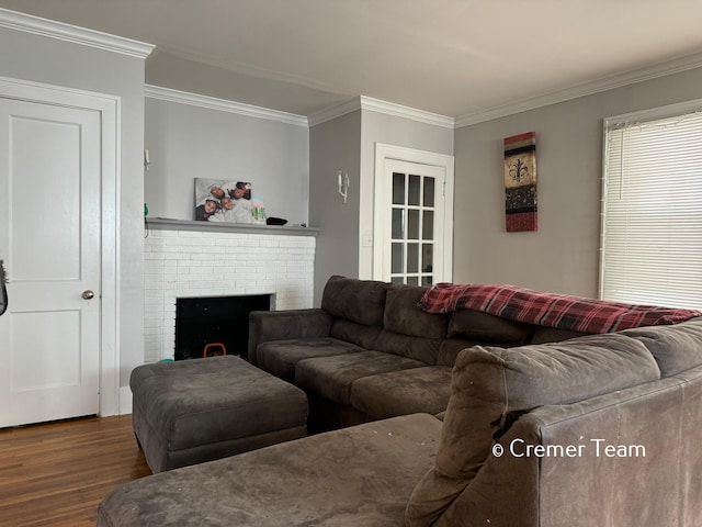 living room with crown molding, dark hardwood / wood-style flooring, and a brick fireplace