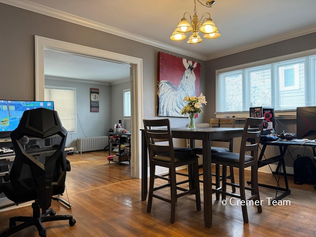 dining space with radiator, crown molding, a notable chandelier, and hardwood / wood-style floors