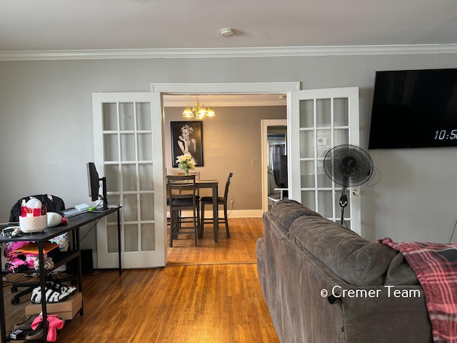 living room with hardwood / wood-style flooring, ornamental molding, and an inviting chandelier