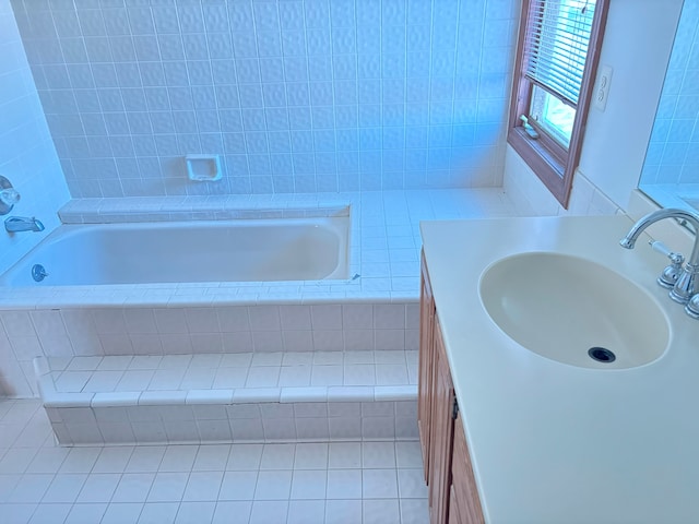 bathroom with tile patterned flooring, vanity, and a relaxing tiled tub