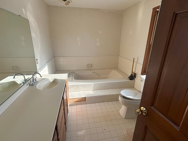 bathroom featuring vanity, tiled tub, tile patterned floors, and toilet