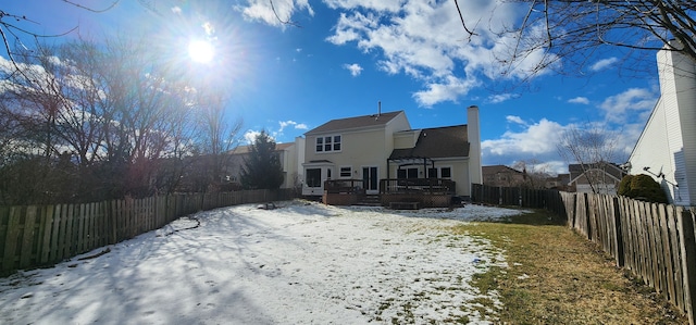 snow covered back of property featuring a wooden deck