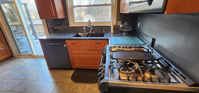 kitchen with dark stone counters, dishwasher, sink, and light tile patterned floors