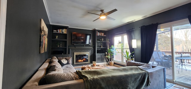 living room with crown molding, a brick fireplace, hardwood / wood-style floors, and ceiling fan