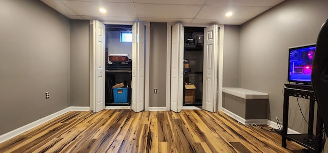 unfurnished bedroom featuring hardwood / wood-style flooring and a drop ceiling