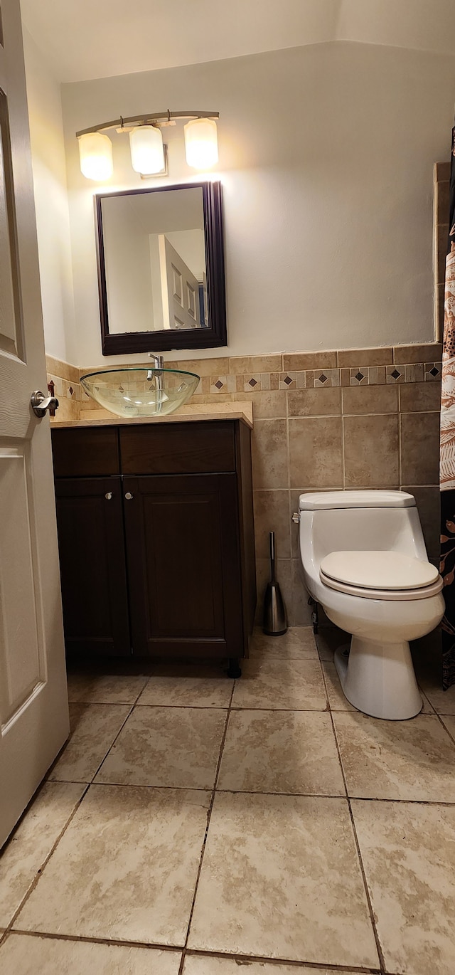 bathroom featuring tile walls, vanity, and toilet