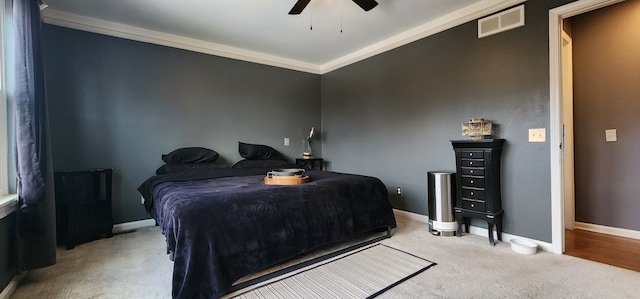 bedroom with ceiling fan, ornamental molding, and light colored carpet