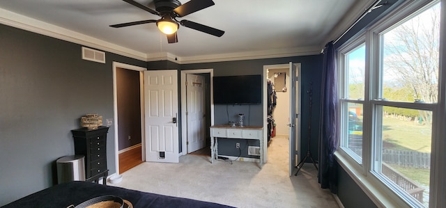 bedroom featuring crown molding, light colored carpet, and ceiling fan