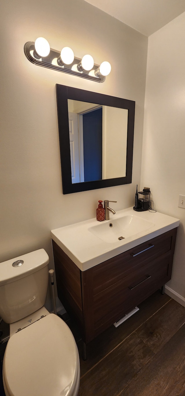 bathroom with vanity, toilet, and wood-type flooring