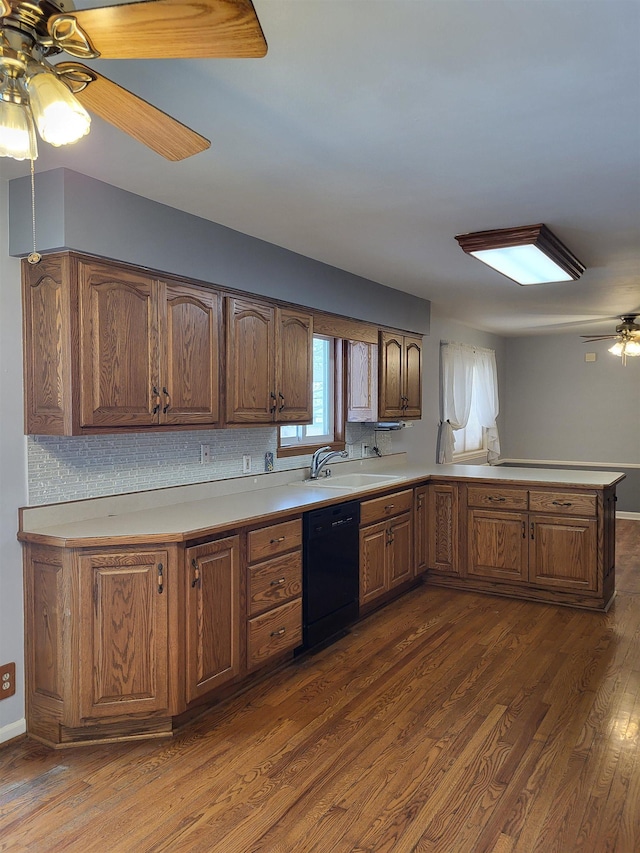 kitchen featuring dark hardwood / wood-style floors, black dishwasher, sink, ceiling fan, and kitchen peninsula