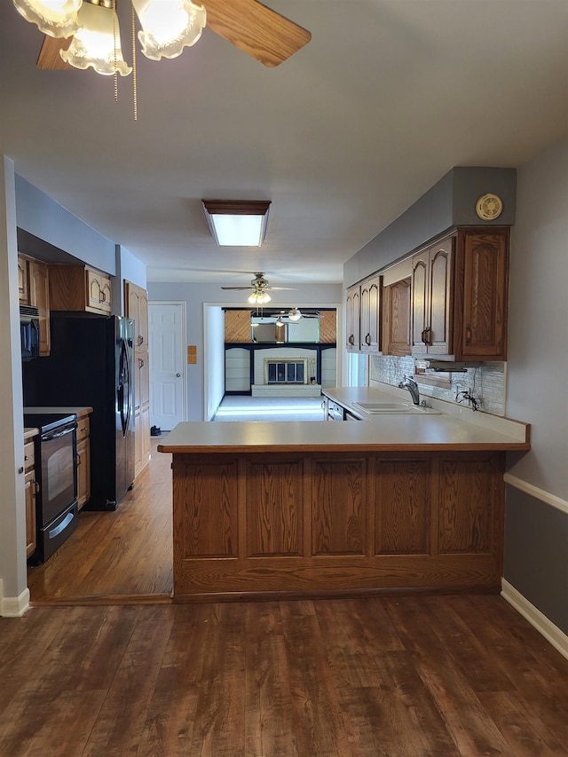 kitchen featuring sink, electric range, dark hardwood / wood-style flooring, and kitchen peninsula