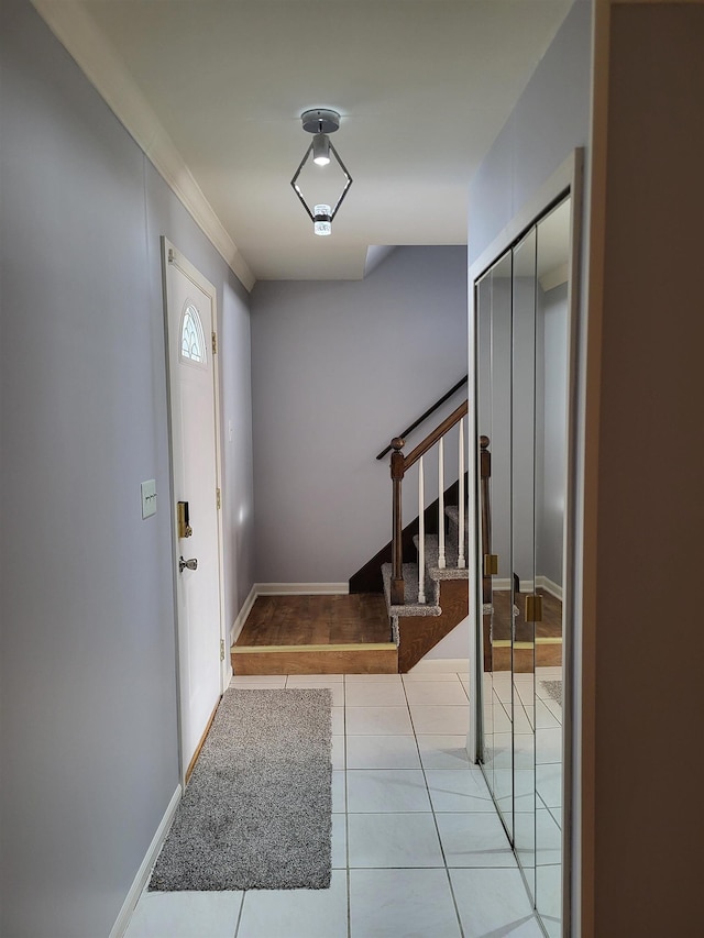 foyer featuring light tile patterned floors and crown molding