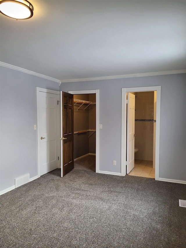 unfurnished bedroom featuring ornamental molding, connected bathroom, a spacious closet, and light carpet