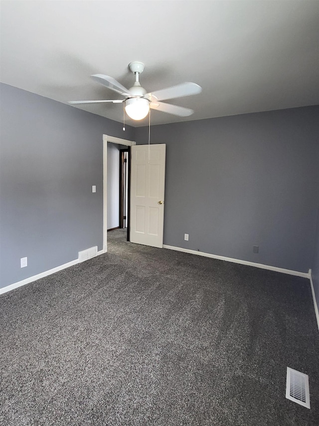 empty room featuring ceiling fan and carpet