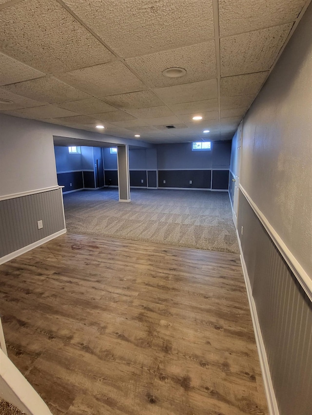 basement with hardwood / wood-style floors and a drop ceiling