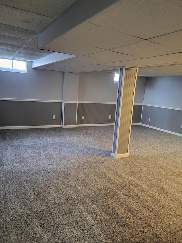 basement with carpet and a paneled ceiling