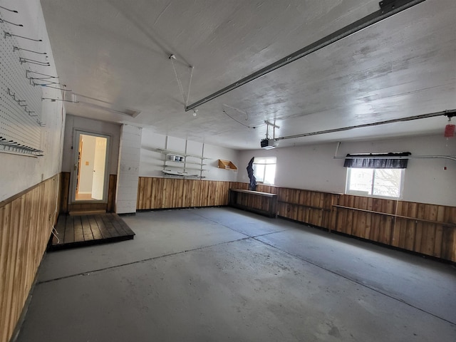 garage with a garage door opener and wooden walls