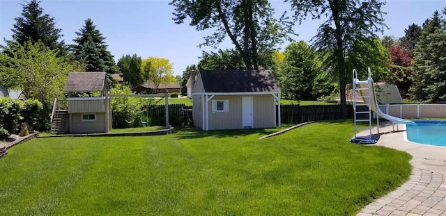 view of yard featuring a fenced in pool and a storage unit