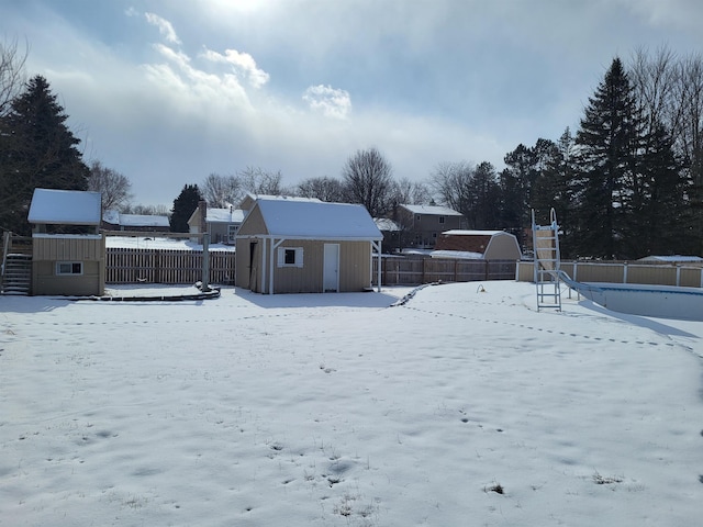 yard covered in snow featuring a storage unit