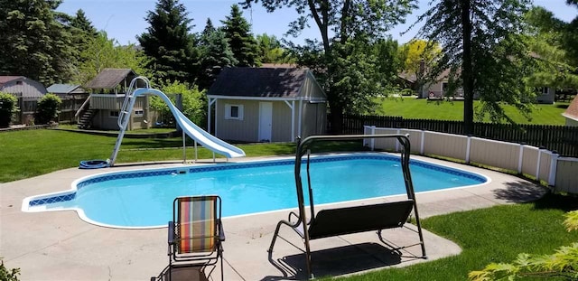 view of swimming pool featuring a storage shed, a water slide, a yard, a patio area, and a playground