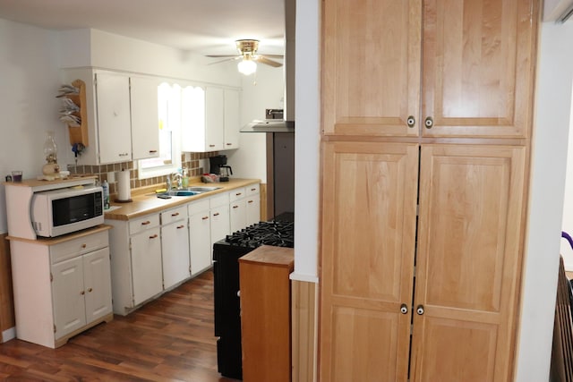 kitchen with gas range, sink, white cabinets, and dark hardwood / wood-style floors